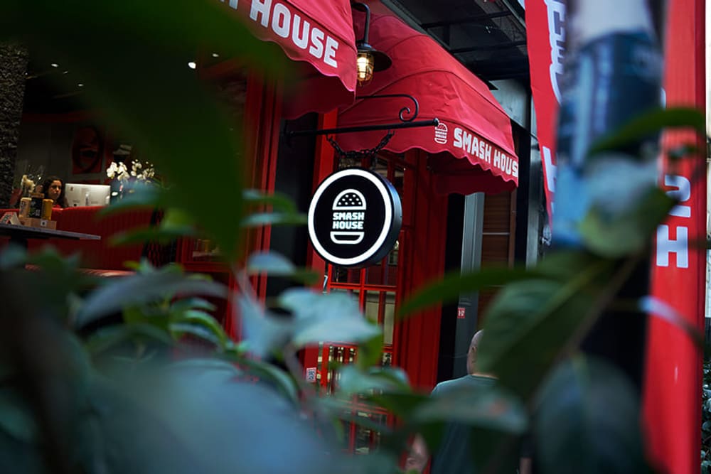 Smash House tabelası ve kırmızı tenteler